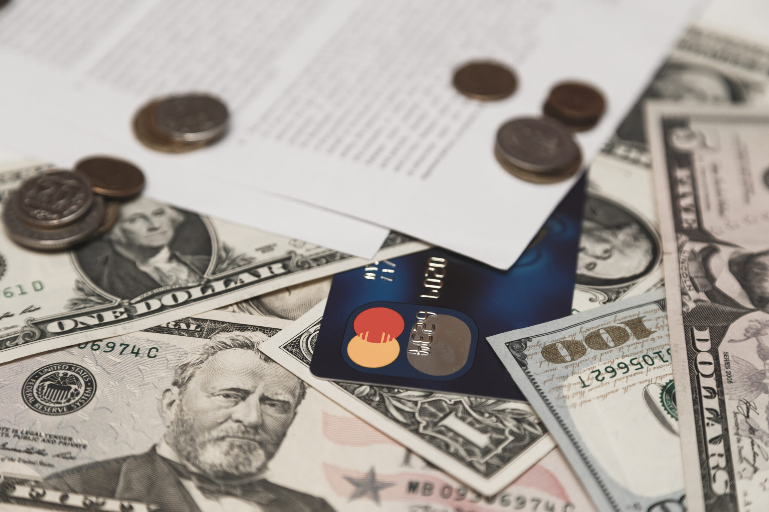 Bank credit card, moneys and coins and bank contract on background.