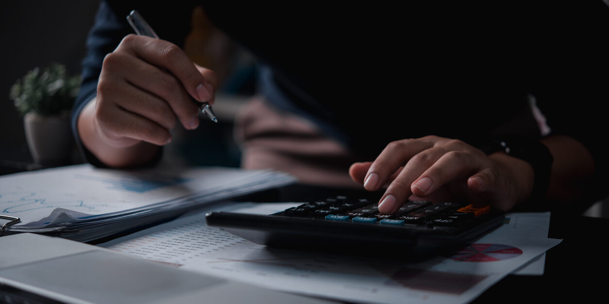 Businessman using calculator bookkeeping payroll and budget tax. Business document finance accounting investment