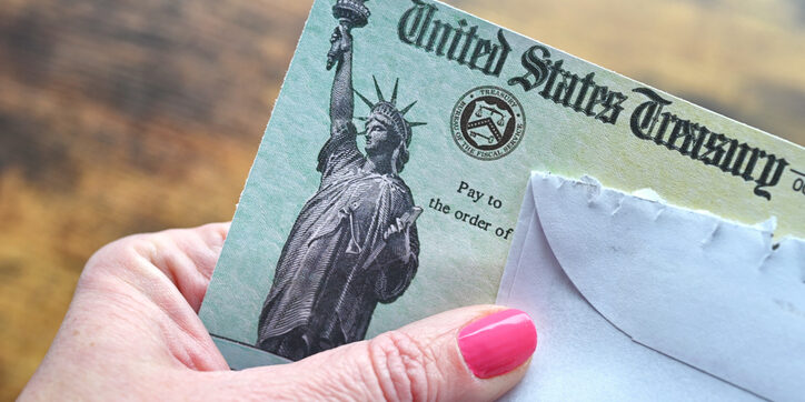 Female holding a check from the United States Treasury