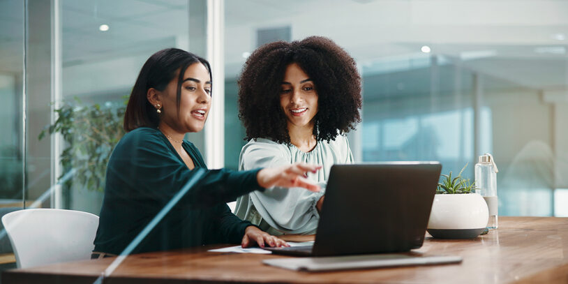 Laptop, feedback and meeting with business women in office for report, discussion and proposal. Collaboration, update and pointing with teamwork in workplace for conversation, review or strategy